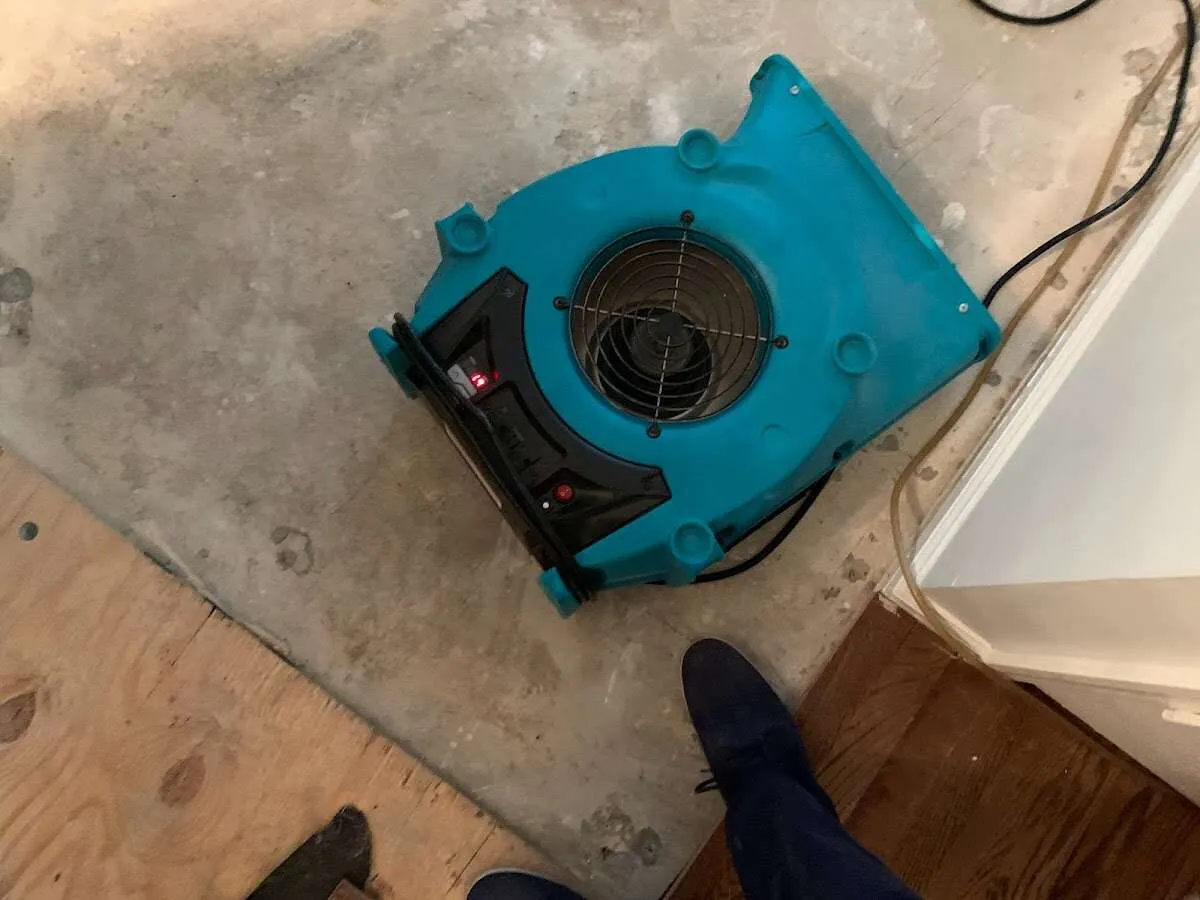 Air mover drying subfloor during Commercial Water Damage Restoration in Byram